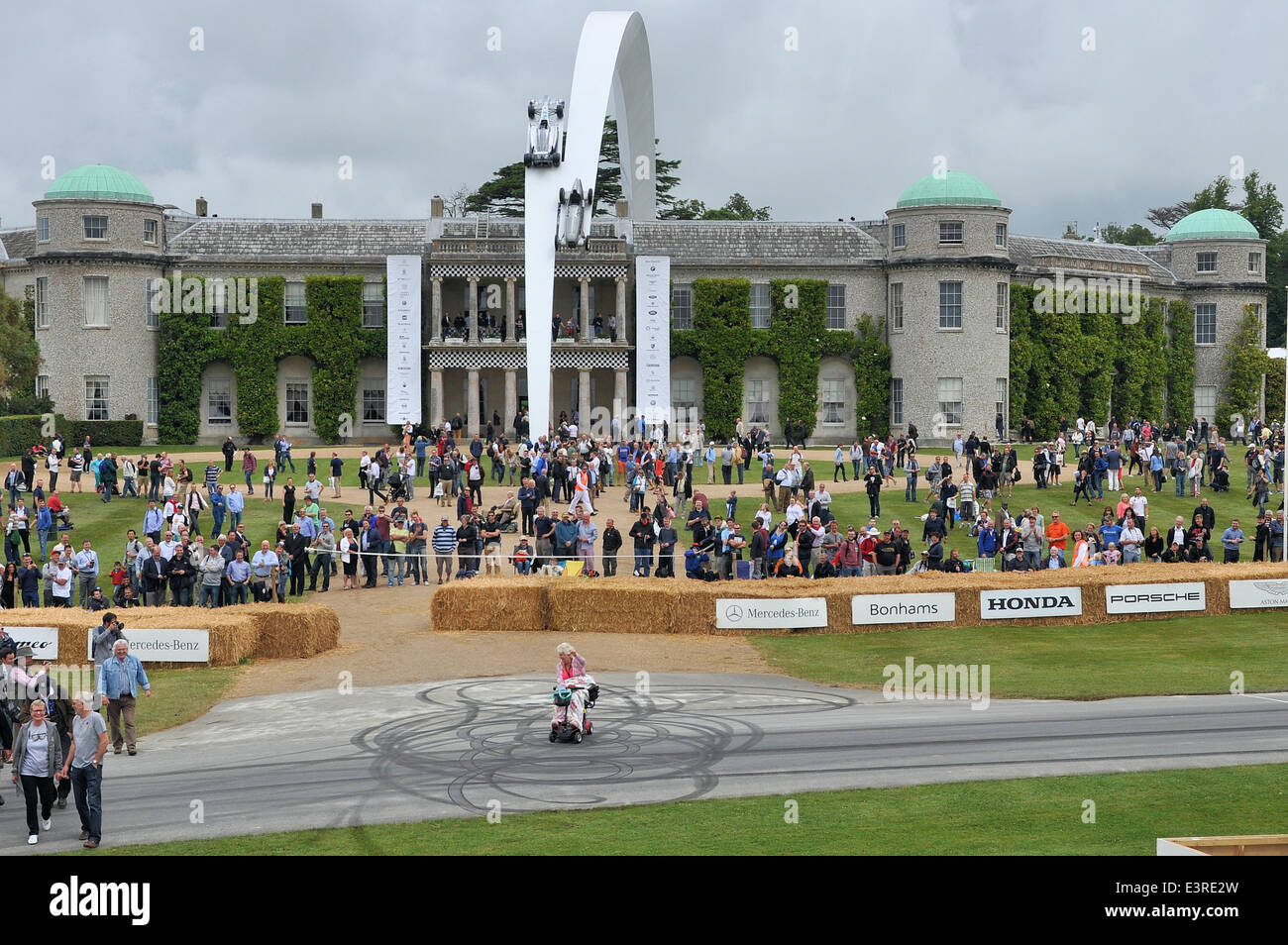 Woman in a mobility scooter doing donuts in front of Goodwood House. Comedy  moment during Festival of Speed racing event Stock Photo - Alamy