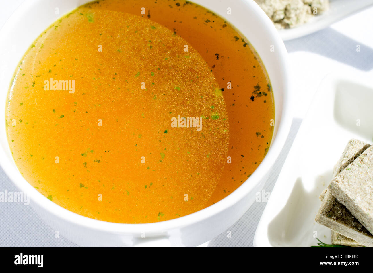 Concentrated broth, bouillon, clear soup in a cup and a bouillon cube