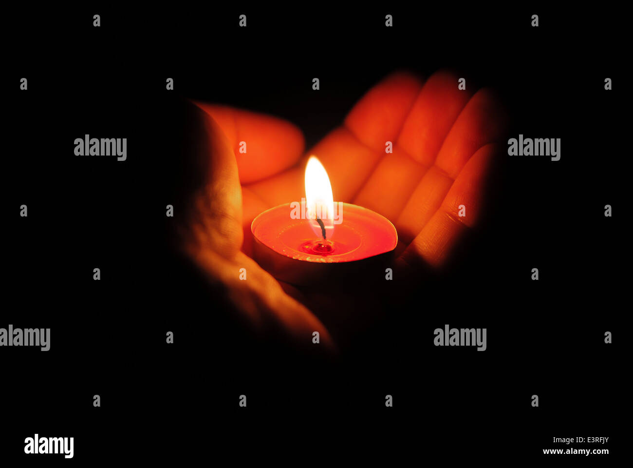 left hand holding a burning candle in dark Stock Photo Alamy