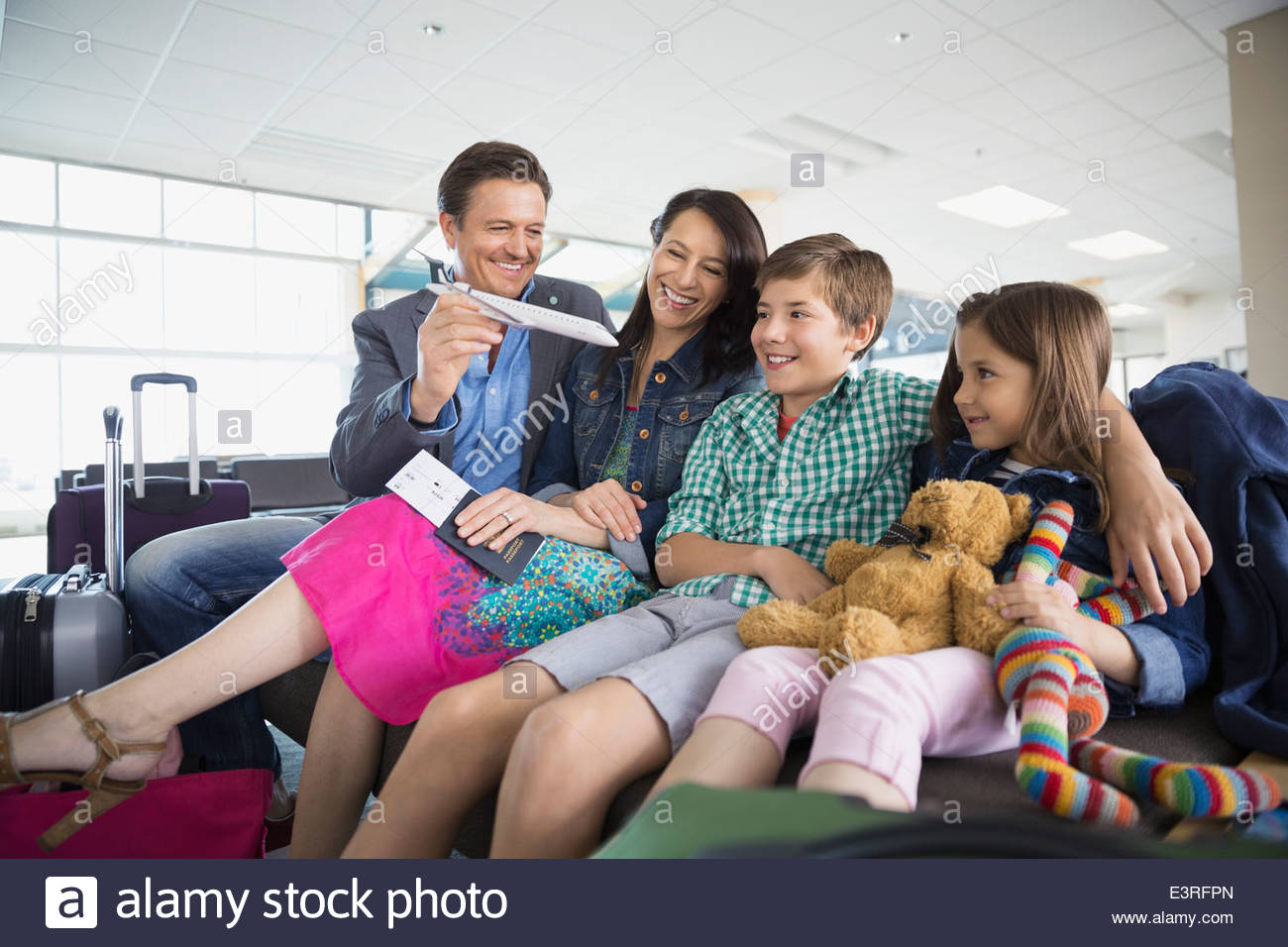 Family with toy airplane waiting in airport Stock Photo