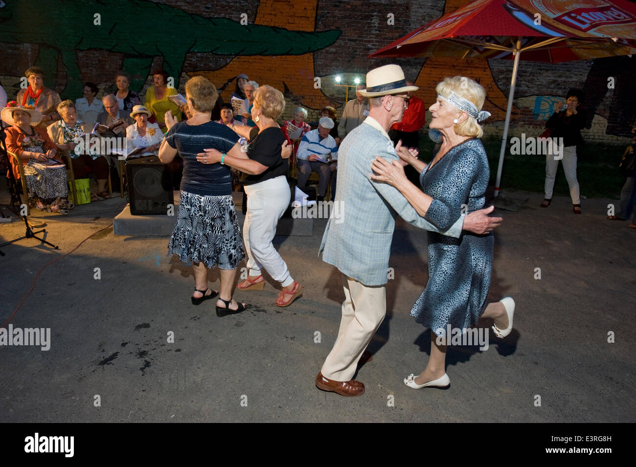 Warsaw, Poland. 27th June, 2014. Friday night is party time, even for residents of a retirement home in the old, eastern part of Warsaw, the capital of Poland. Accompanied by young musicians, the informal choir of golden agers presented a number of traditional urban folklore songs. After sunset, fleet-footed blue-hairs filled the open-air dance floor at Brzeska Street. Credit:  Henryk Kotowski/Alamy Live News Stock Photo