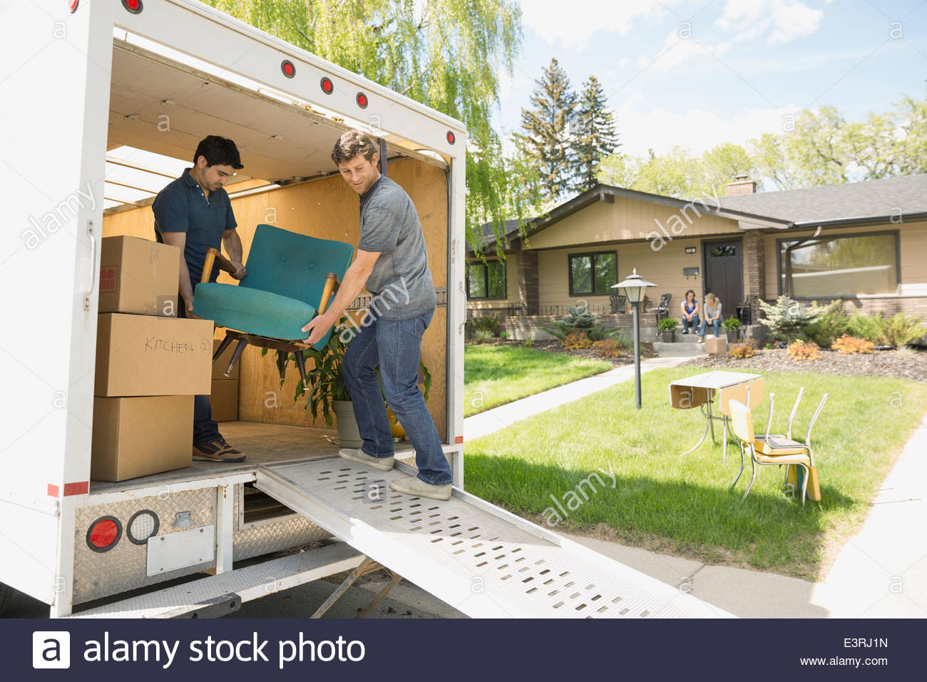 Men unloading chair from moving van Stock Photo