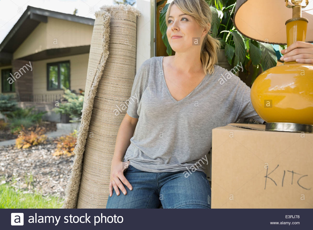 Woman unloading belongings from moving van Stock Photo
