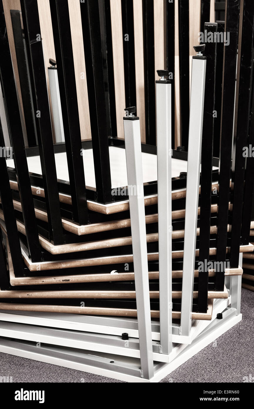 Inverted upside down stacked metal tables deck legs making a pattern of bars spiraling upwards at corners Stock Photo