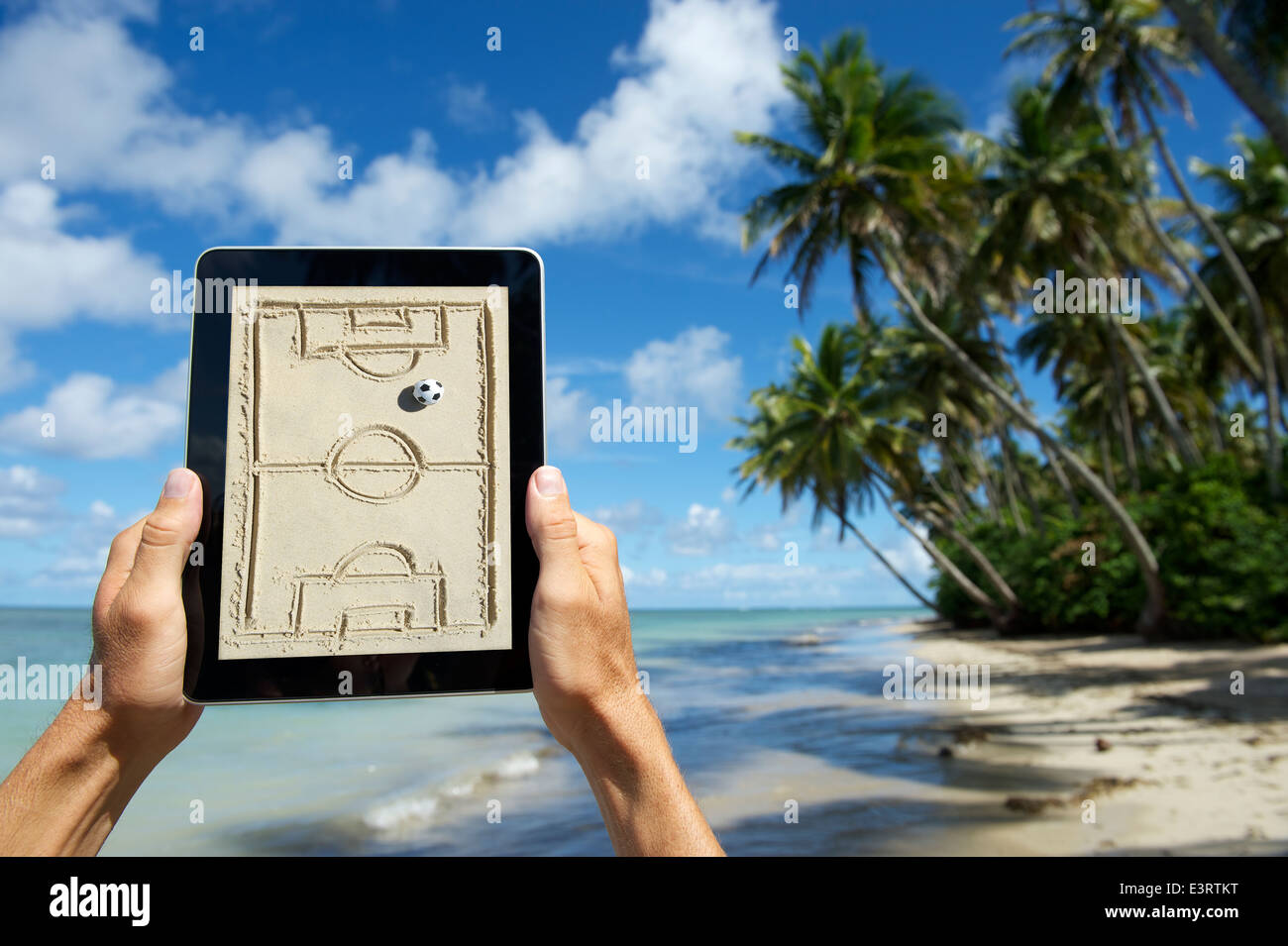 Hands holding football tactics board tablet on the beach in Nordeste Bahia Brazil Stock Photo