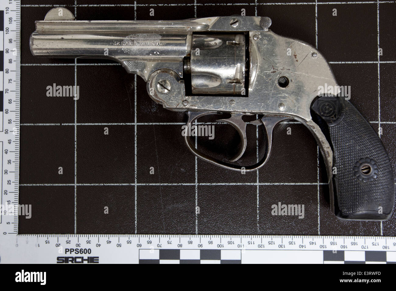 Handgun after treatment for fingerprints using florescence powder prior to being photographed under ultraviolet light Stock Photo