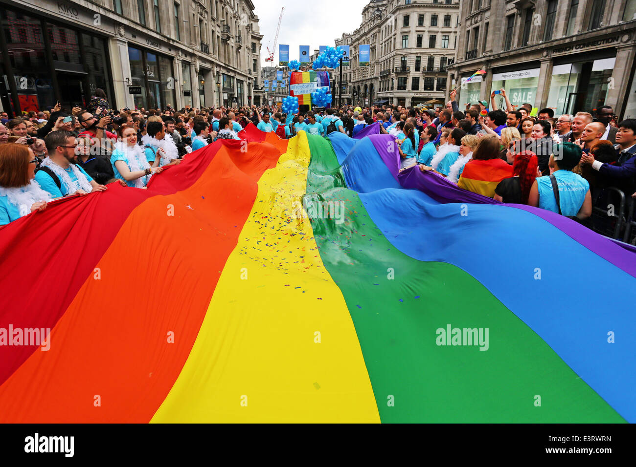 London, UK. 28th June 2014. Giant rainbow flag at the Pride London Parade 2014 in London. Rain storms throughout the day didn't dampen the spirits of the 20,000 people in the parade of the crowds in the packed streets watching. It did however bring out plenty of rainbow umbrellas. Credit:  Paul Brown/Alamy Live News Stock Photo