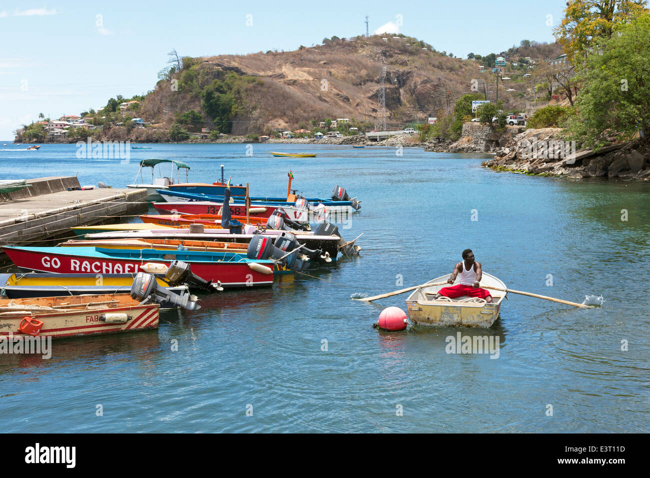 Local fisherman rowing in the small harbour area of the fish market at St George, Grenada, west Indies Stock Photo