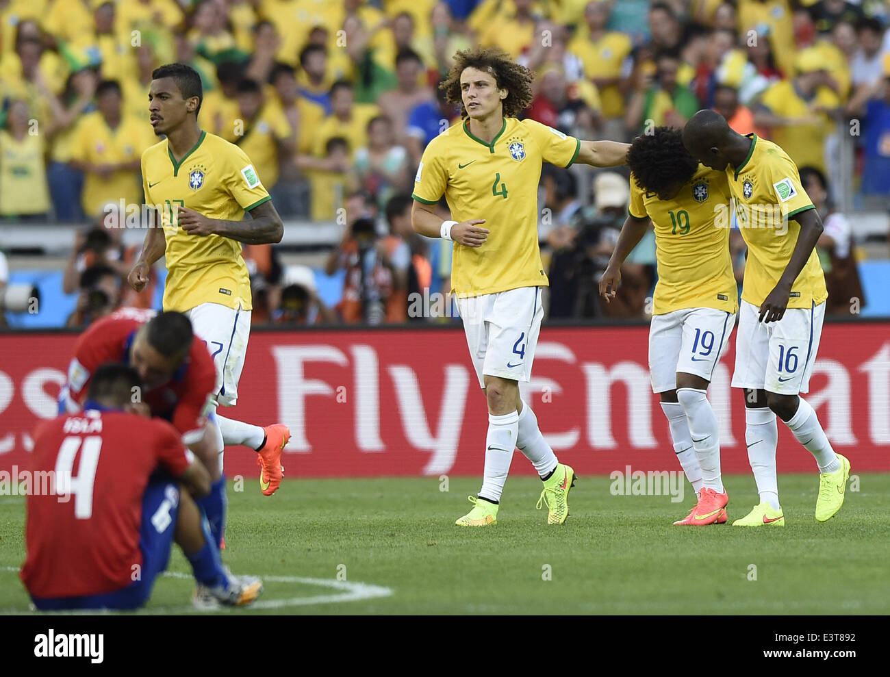 Belo Horizonte, Brazil. 28th June, 2014. Brazil's Ramires (1st R) and David Luiz (3rd R) comfort Willian (2nd R) who missed a penalty goal in the penalty shoot-out during a Round of 16 match between Brazil and Chile of 2014 FIFA World Cup at the Estadio Mineirao Stadium in Belo Horizonte, Brazil, on June 28, 2014. Brazil won 4-3 (3-2 in penalties) over Chile and qualified for Quarter-finals on Saturday. Credit:  Qi Heng/Xinhua/Alamy Live News Stock Photo