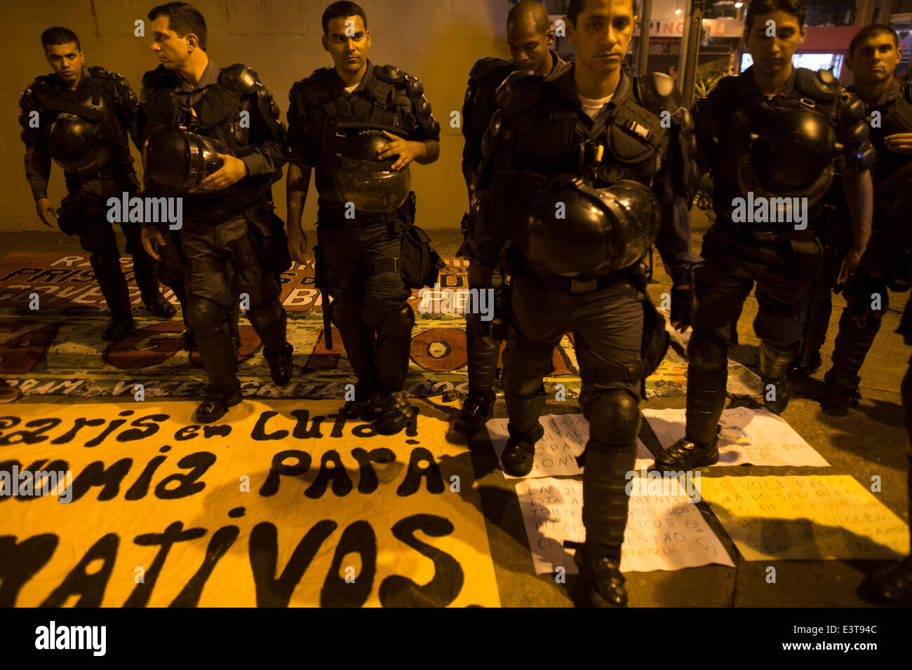 Rio De Janeiro, Brazil. 28th June, 2014. Police officers step on cardboards of demonstrators during a protest against FIFA World Cup outside the Estadio Maracana Stadium during a Round of 16 match between Colombia and Uruguay of 2014 FIFA World Cup, in Rio de Janeiro, Brazil, on June 28, 2014. Credit:  Guillermo Arias/Xinhua/Alamy Live News Stock Photo