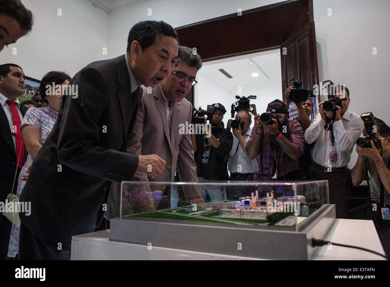 Caracas. 28th June, 2014. Chinese Ambassador to Venezuela Zhao Rongxia (L) and Venezuelan Chancellor Elias Jaua (2nd L) attend the opening ceremony of the photo exhibition 'Achievements between China and Venezuela' marking the 40th anniversary of the establishment of the diplomatic relations between China and Venezuela, in Caracas June 28, 2014. The Francisco de Miranda Youth Symphony Orchestra performed during the event on Saturday. © Boris Vergara/Xinhua/Alamy Live News Stock Photo