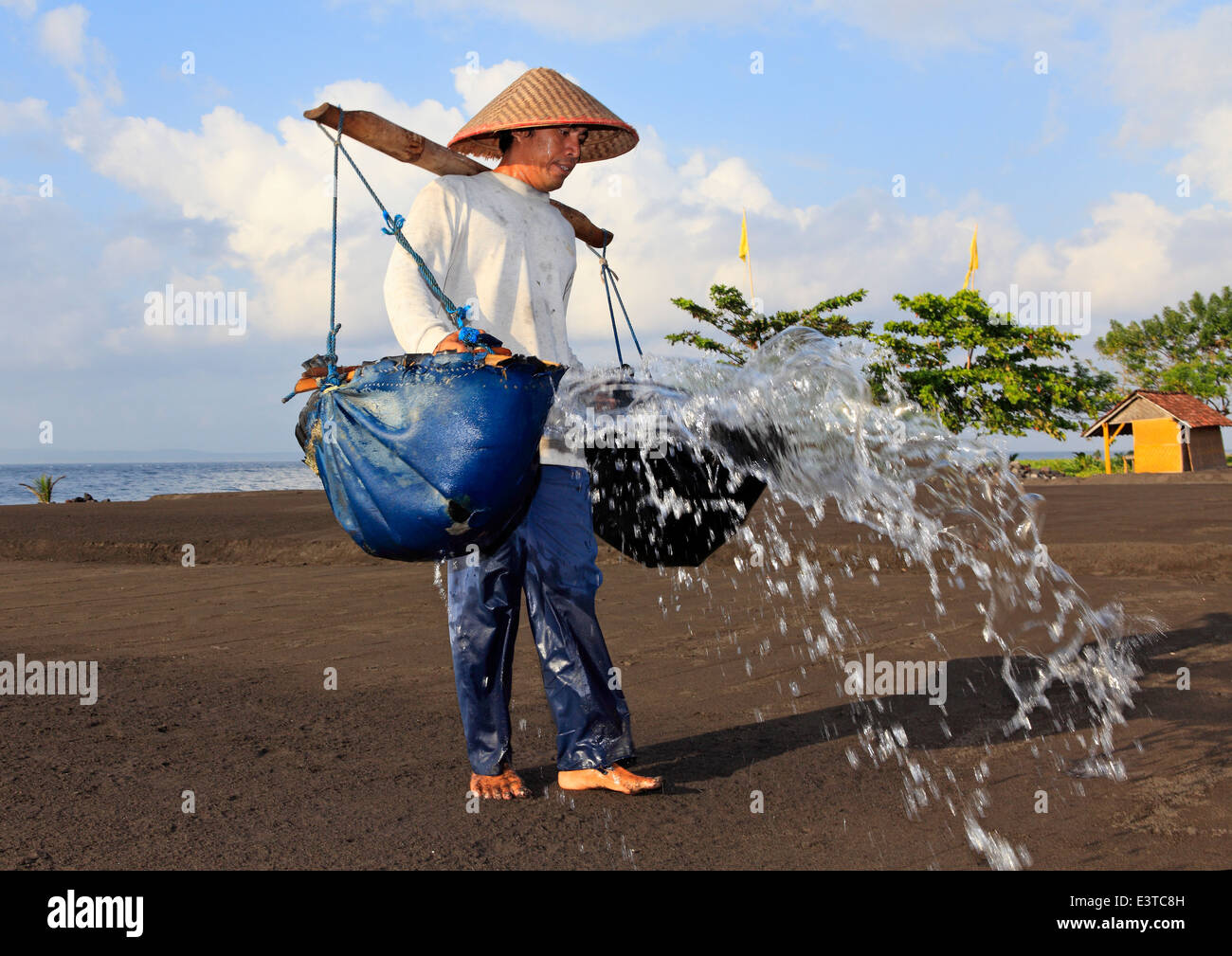 One of the few remaining traditional salt makers in Bali, at Kusamba Beach. Bali, Indonesia. Stock Photo