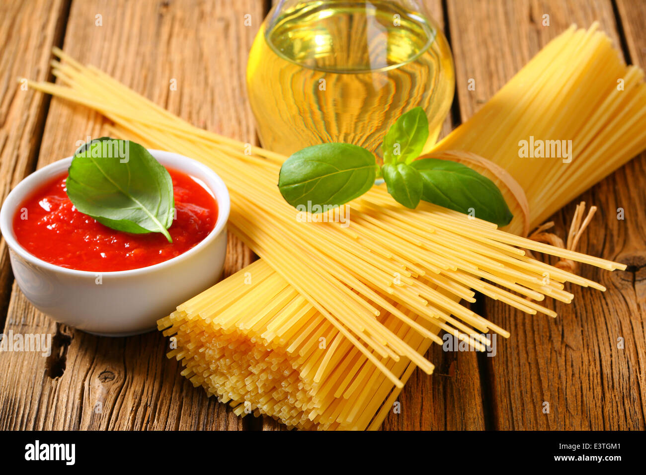 Still life of dried spaghetti, tomato puree and olive oil Stock Photo