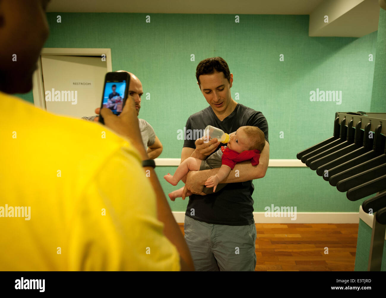 Manhattan, New York, USA. 21st June, 2014. Chris Lee, 36, of the Upper West Side takes a photo of Michael Friedland, 32, of Boerum Hill feeding David Franzson's (center) 13-week old daughter Isold as expectant dads learn about diaper changing, feeding and other issues from ''Daddy Boot Camp'' instructor Tim Mulvaney and other dads in Tribeca, Saturday June 21, 2014. © Bryan Smith/ZUMAPRESS.com/Alamy Live News Stock Photo