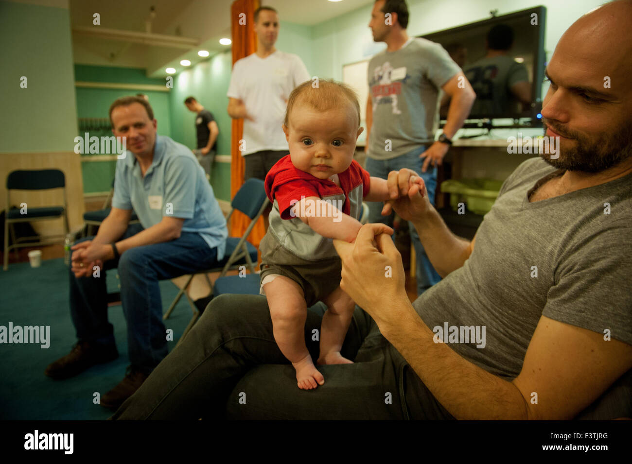 Manhattan, New York, USA. 21st June, 2014. David Franzson, 36 of Tribeca, holds his 13-week old daughter Isold as expectant dads including Larry Hausman (left), 42, of Holbrook, Evan Parker-Stephen (center), 35 of the Upper West Side and Rocco Rotondi (right), 36, of Floral Park look on as they learn about diaper changing, feeding and other issues from ''Daddy Boot Camp'' instructor Tim Mulvaney and other dads in Tribeca, Saturday June 21, 2014. © Bryan Smith/ZUMAPRESS.com/Alamy Live News Stock Photo