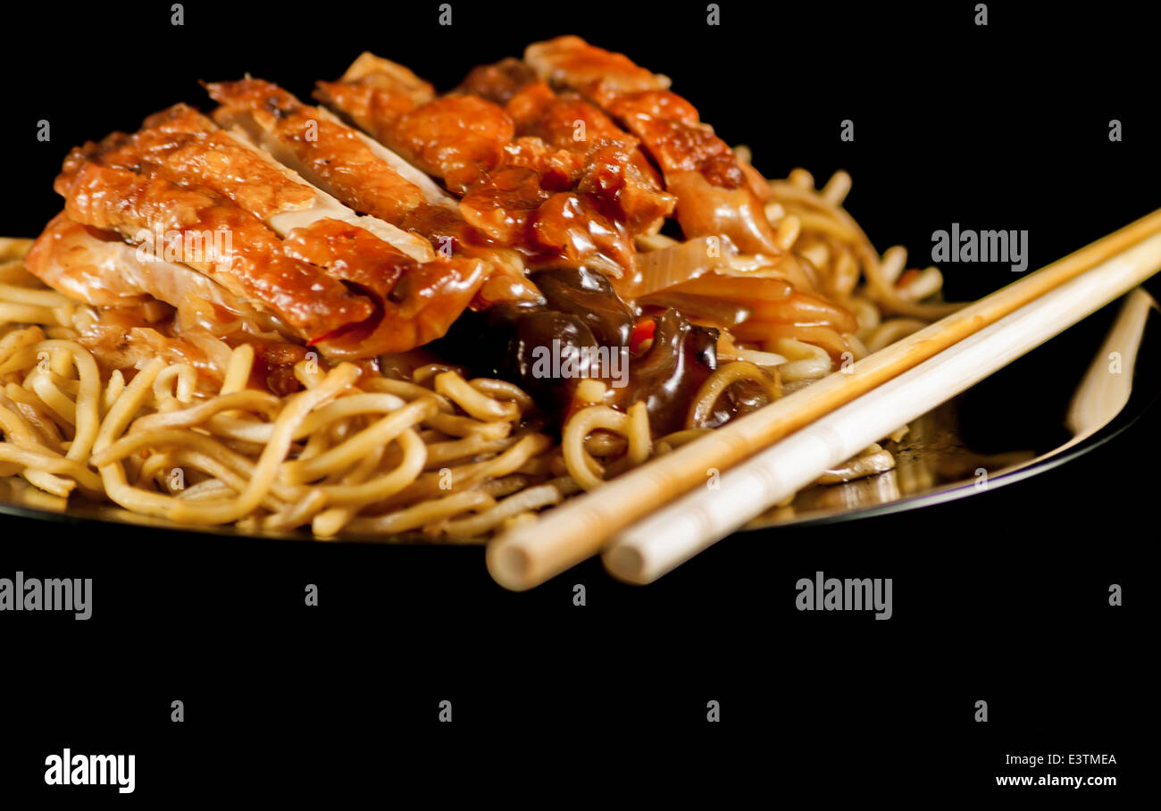 chinese noodle with chicken and vegetables on black background Stock
