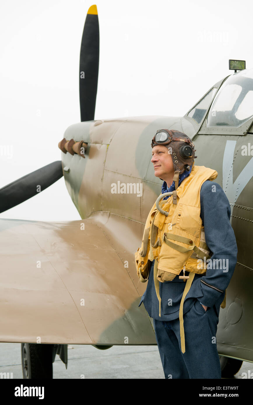 WW2 RAF pilot, wearing his Mae West life jacket, stands ready beside his Spitfire fighter aircraft. Stock Photo