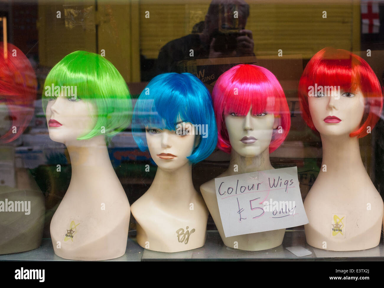 Colourful Wigs on mannequin in shop window. Stock Photo