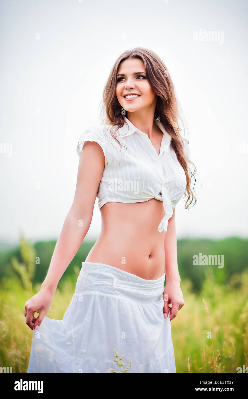 Portrait of happy smiling beautiful young woman in a field Stock Photo
