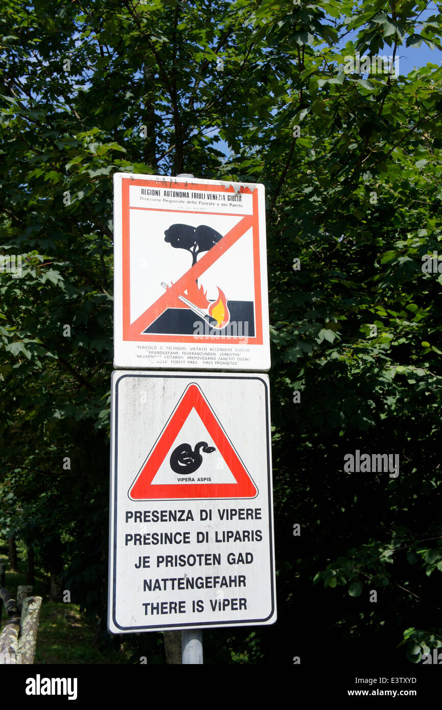 Warning signs in Plessiva Wood about the dangers of fire and snakes in Italian, Friuilian, Slovene, German, and English Stock Photo