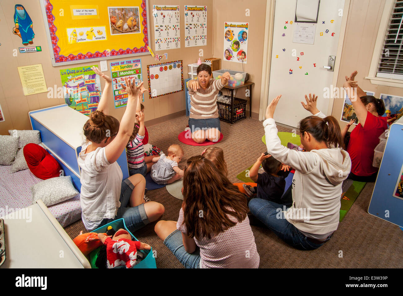 Mothers and their young children attend a "Learning Link" classroom in  Tustin, CA, where a Hispanic teacher conducts a workshop in interactive  behavior. Using specially designed activities, the class teaches parents how