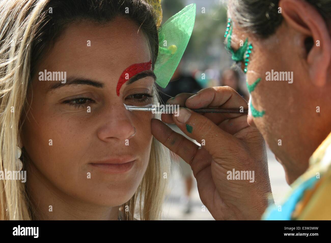 Rio de Janeiro, Brazil. 29th June 2014. 2014 FIFA World Cup Brazil. A young Brazilian having her face painted in the colors of the Dutch flag, before going to the FIFA Fan Fest in Copacabana Beach, before the match Netherlands 2x1 Mexico in the Round of 16. Face painting is very popular among fans in the World Cup. Rio de Janeiro, Brazil, 29th June, 2014. Credit:  Maria Adelaide Silva/Alamy Live News Stock Photo