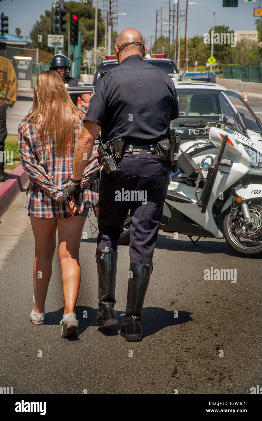 A volunteer high school girl is arrested by a policeman in a dramatization of the dangers of drunk driving in Anaheim, CA. Stock Photo