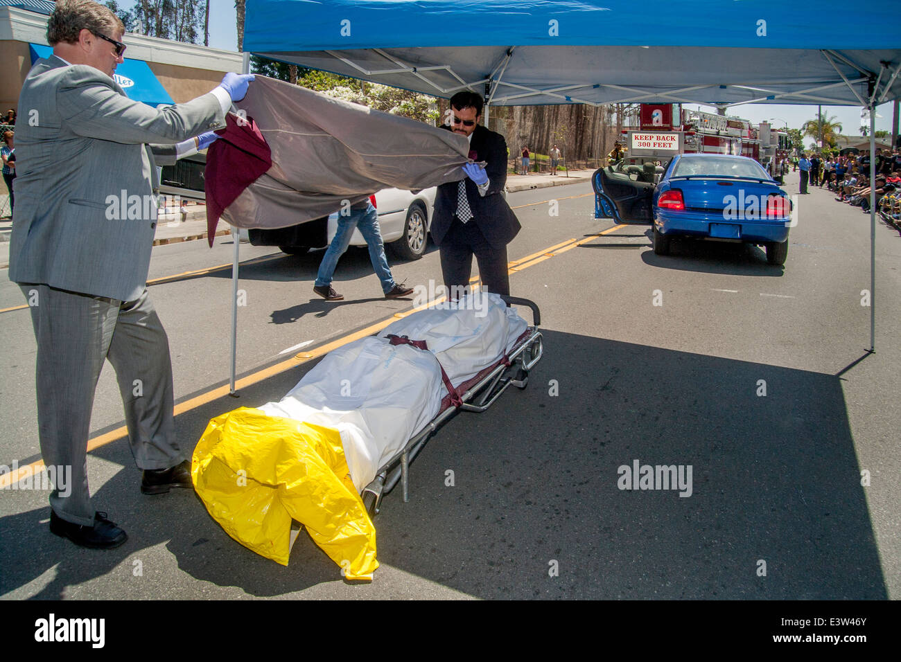 Local volunteer undertakers collect the 'corpse' of an accident victim in a dramatization for a high school audience of the dangers of drunk driving in Anaheim, CA. Note crowd in background. Stock Photo