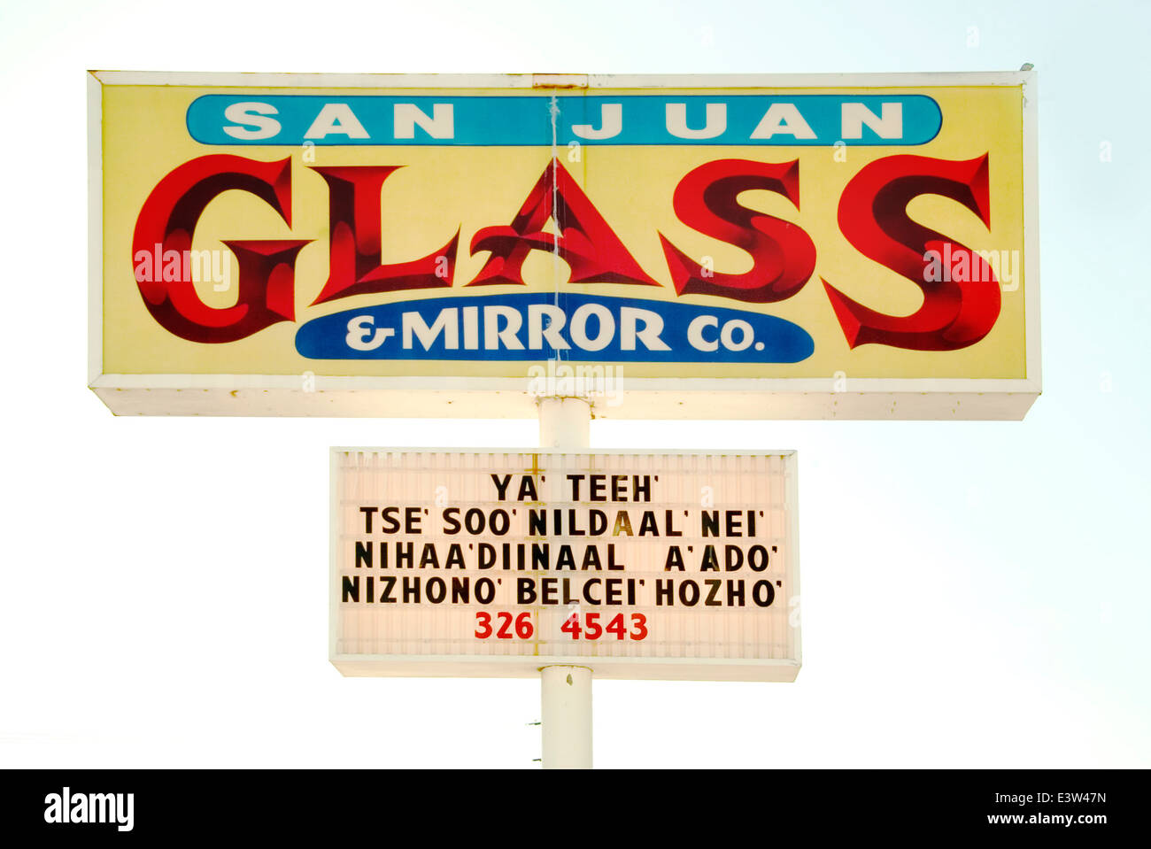 A sign in a phonetic approximation of the Navajo Native American language advertises a glass-and-mirror company in Farmington, New Mexico. Stock Photo