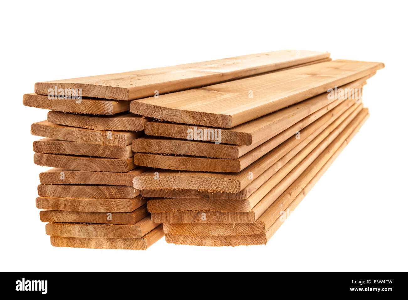 Stacks of one by six inch cedar boards on white background Stock Photo