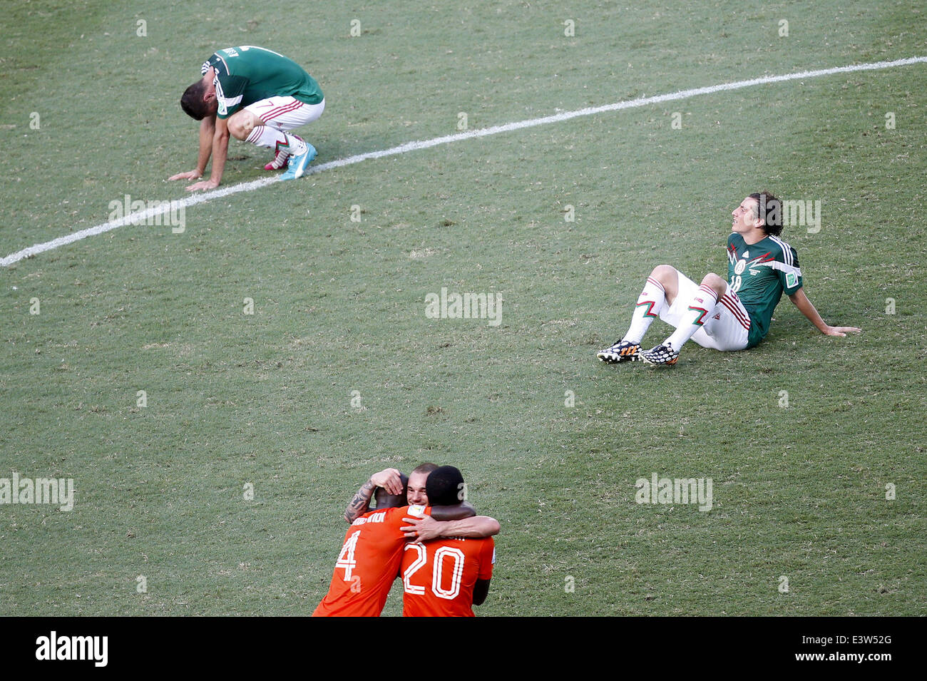 Fortaleza, Brazil. 29th June, 2014. Mexico's Andres Guardado (R) reacts while Netherlands' players celebrate their victory after a Round of 16 match between Netherlands and Mexico of 2014 FIFA World Cup at the Estadio Castelao Stadium in Fortaleza, Brazil, on June 29, 2014. Netherlands won 2-1 over Mexico and qualified for Quarter-finals on Sunday. Credit:  Liao Yujie/Xinhua/Alamy Live News Stock Photo