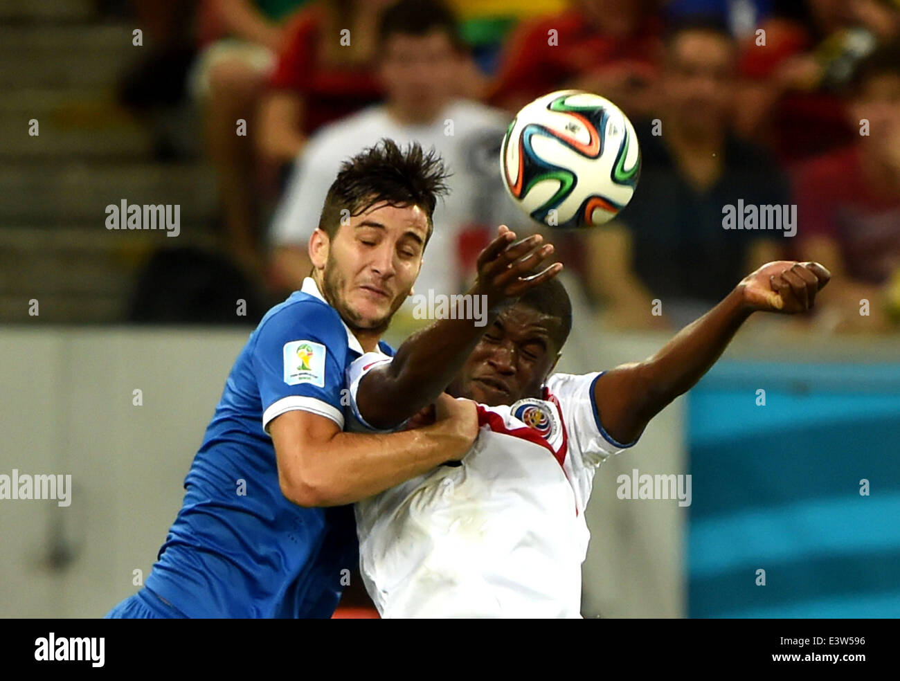 Recife, Brazil. 29th June, 2014. Greece's Kostas Manolas (L) vies for the ball with Costa Rica's Joel Campbell during a Round of 16 match between Costa Rica and Greece of 2014 FIFA World Cup at the Arena Pernambuco Stadium in Recife, Brazil, on June 29, 2014. Credit:  Cao Can/Xinhua/Alamy Live News Stock Photo