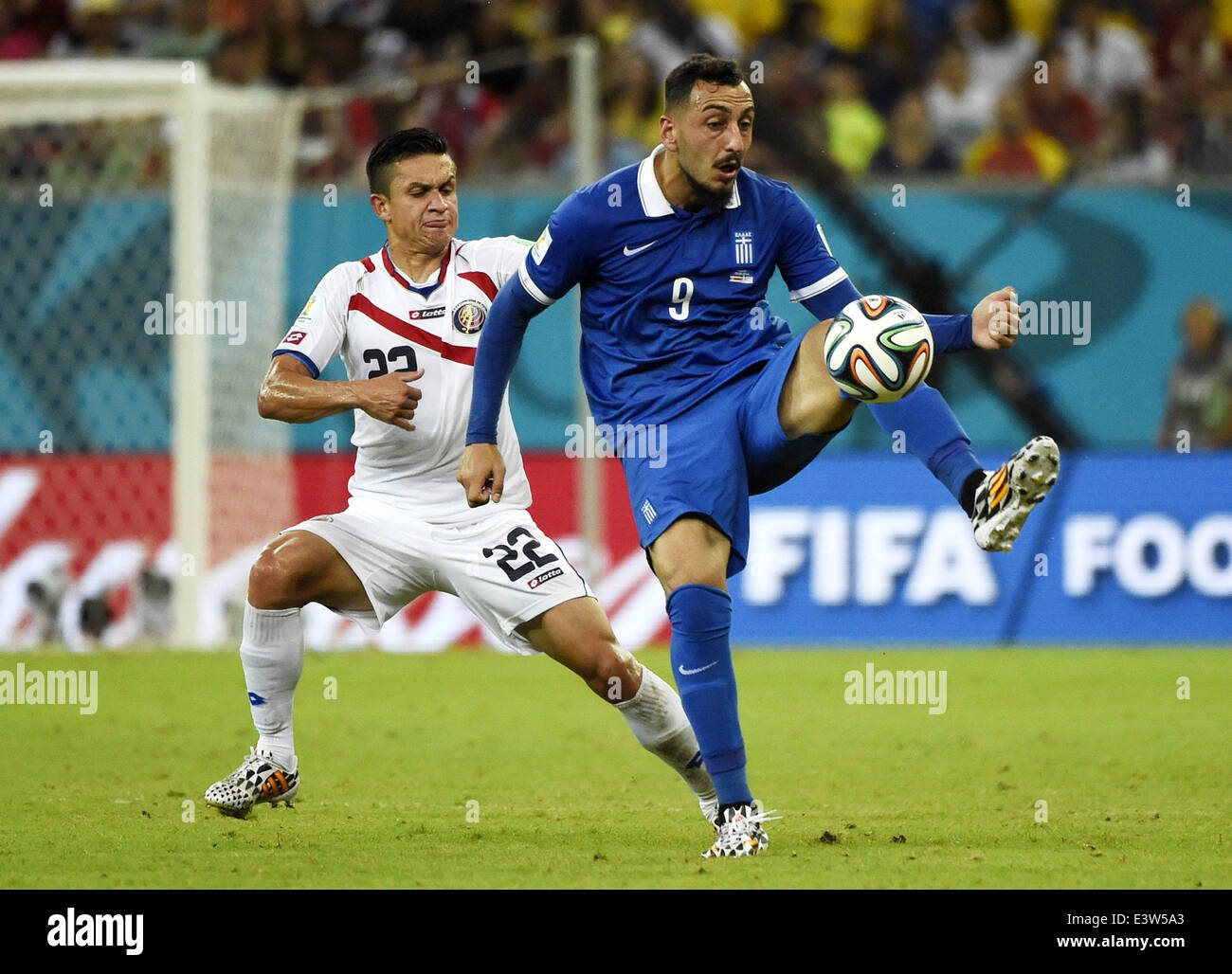 Recife, Brazil. 29th June, 2014. Greece's Konstantinos Mitroglou (R) vies with Costa Rica's Jose Miguel Cubero during a Round of 16 match between Costa Rica and Greece of 2014 FIFA World Cup at the Arena Pernambuco Stadium in Recife, Brazil, on June 29, 2014. Credit:  Lui Siu Wai/Xinhua/Alamy Live News Stock Photo