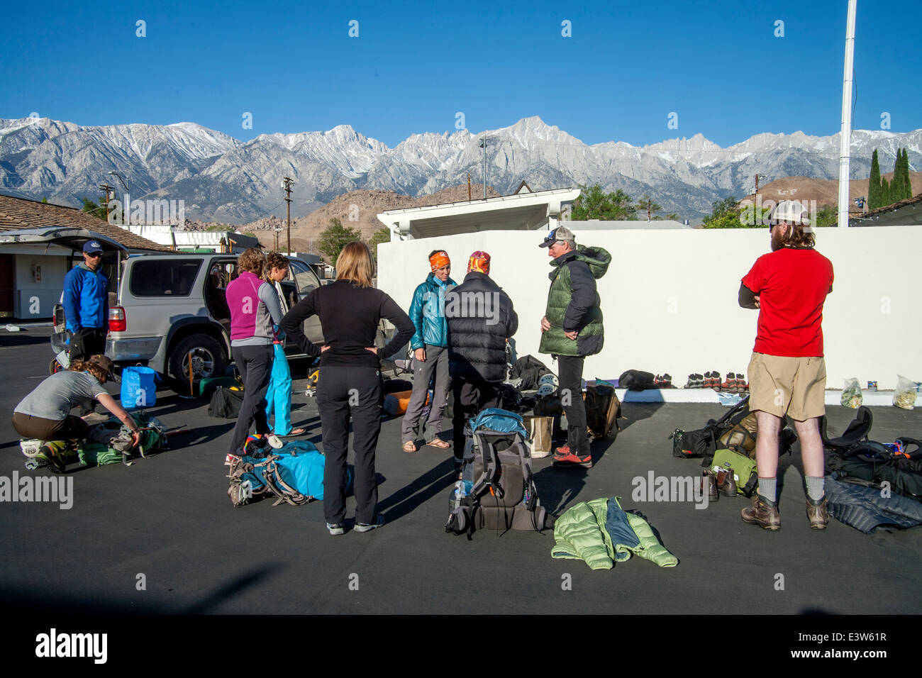 A rock climbing club gathers to organize their equipment before beginning an expedition in Lone Pine, CA. Note Sierra Nevada mountains in background. Stock Photo