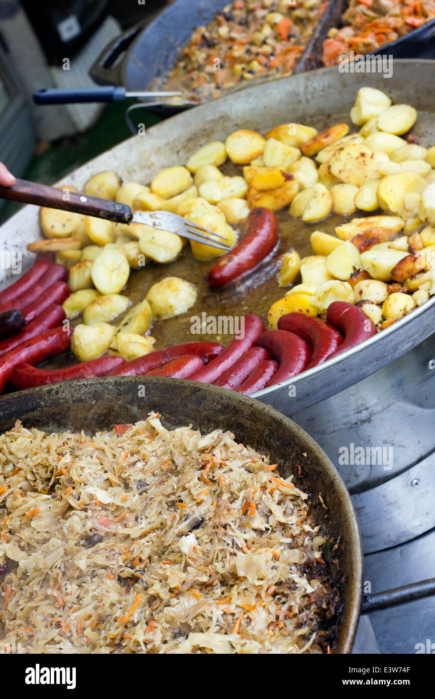 Street food - cabbage stew, smoked sausage and potatoes fried in lard. Selective art focus Stock Photo