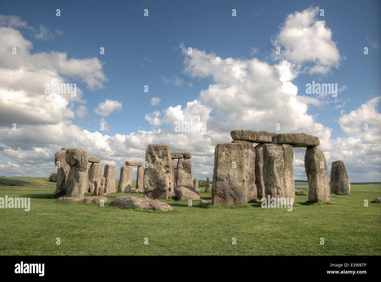 White fluffy clouds floating in a blue sky over the iconic UNESCO World Heritage Site at Stonehenge, Wiltshire, UK. Stock Photo