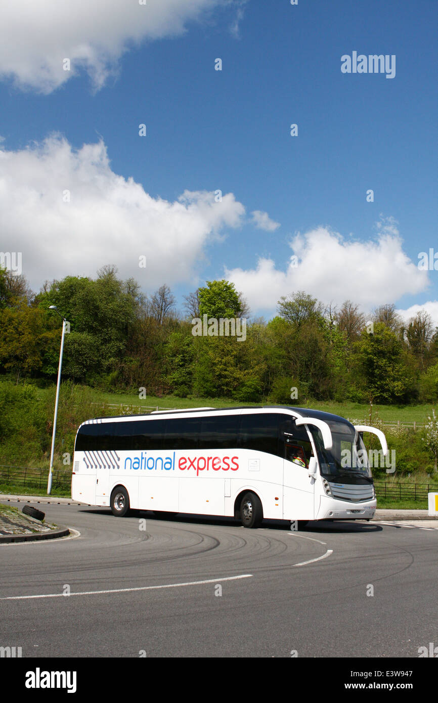 A National Express coach traveling around a roundabout in Coulsdon, Surrey, England Stock Photo