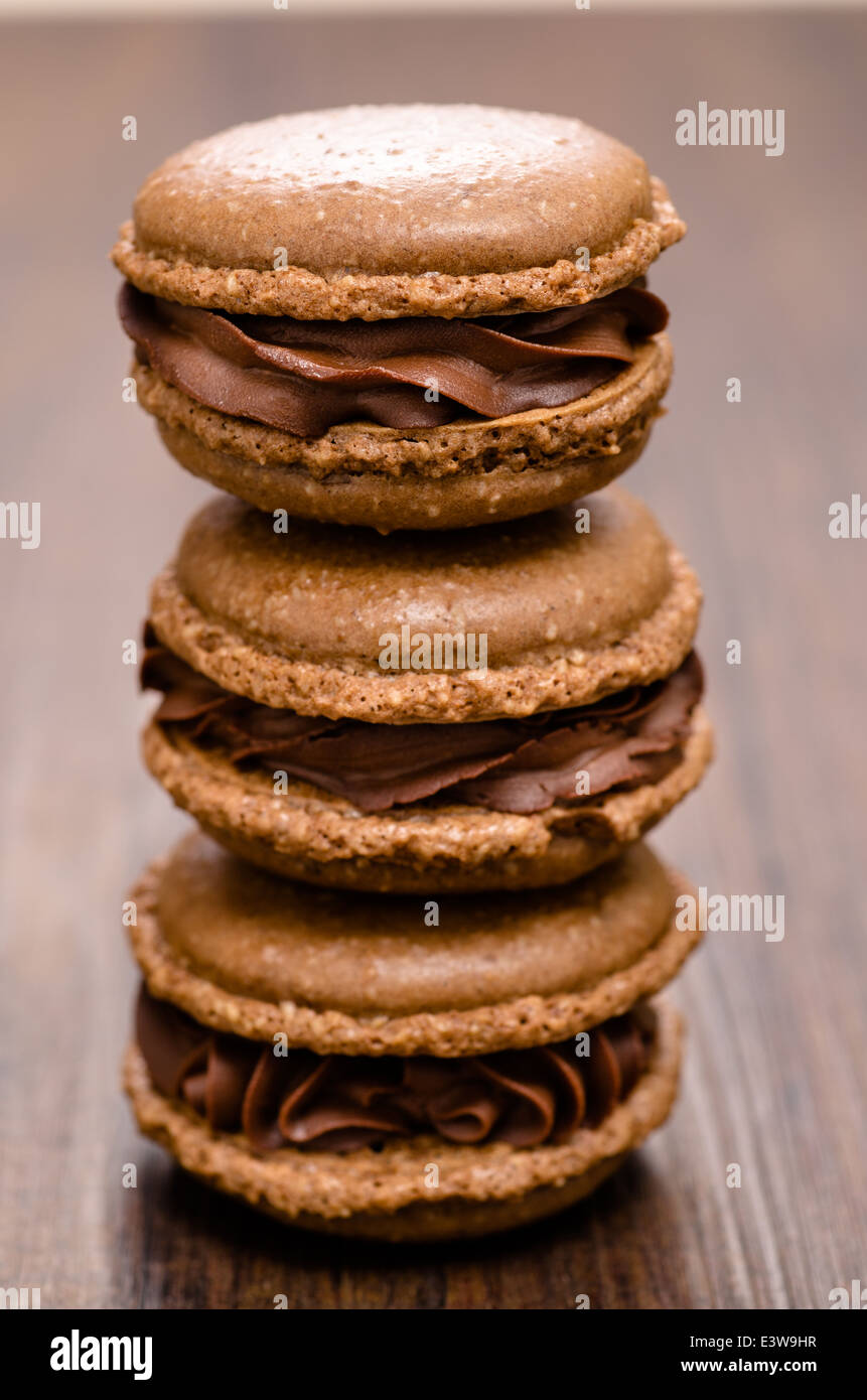 Stack of thee brown chcocolate macarons in vertical format Stock Photo