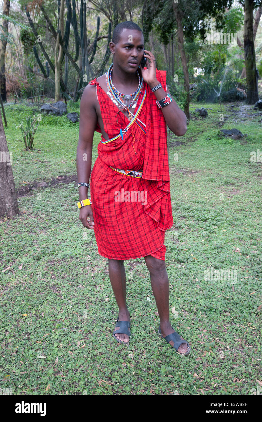 Maasai man in traditional dress using mobile phone in Amboseli National Park Kenya East Africa Stock Photo