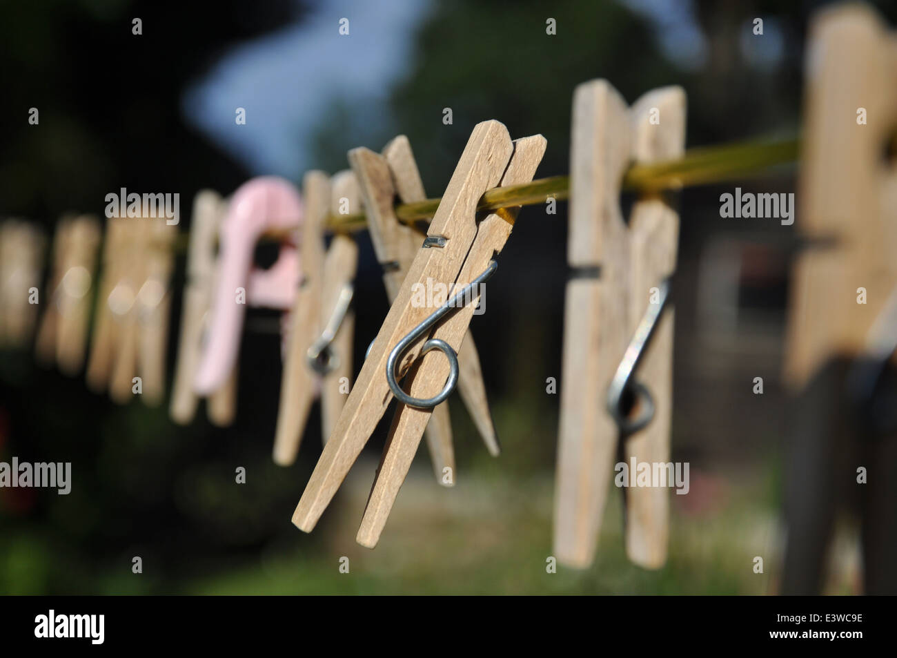 Wooden clothes pegs on a washing line on a sunny day Stock Photo