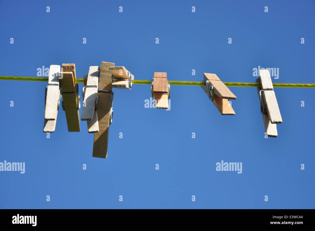 Wooden clothes pegs on a washing line on a sunny day Stock Photo