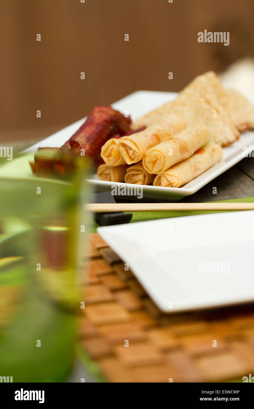 Chinese food appetizers on a platter outside, including spring rolls