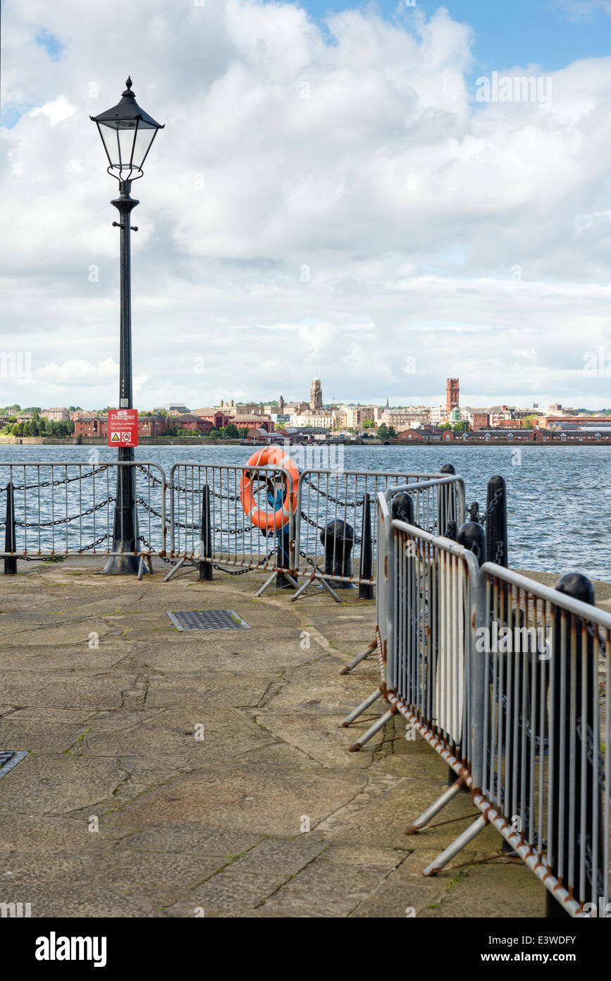 Street lights along the pier-head alongside the River Mersey as it runs through the city of Liverpool. Docks can be seen on the Stock Photo