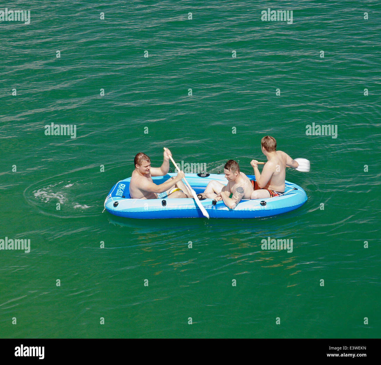 Three men in an inflatable boat. Stock Photo
