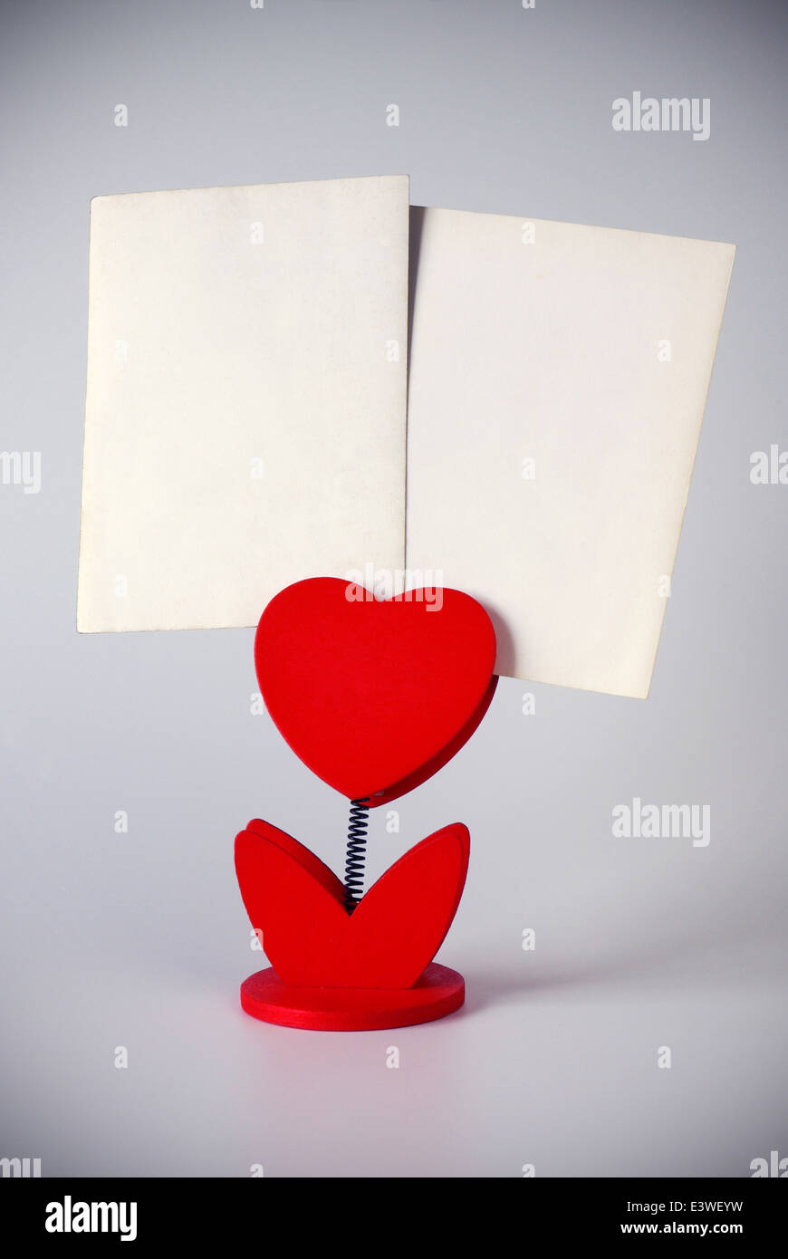 heart-shaped photo holder holding two blank photos Stock Photo
