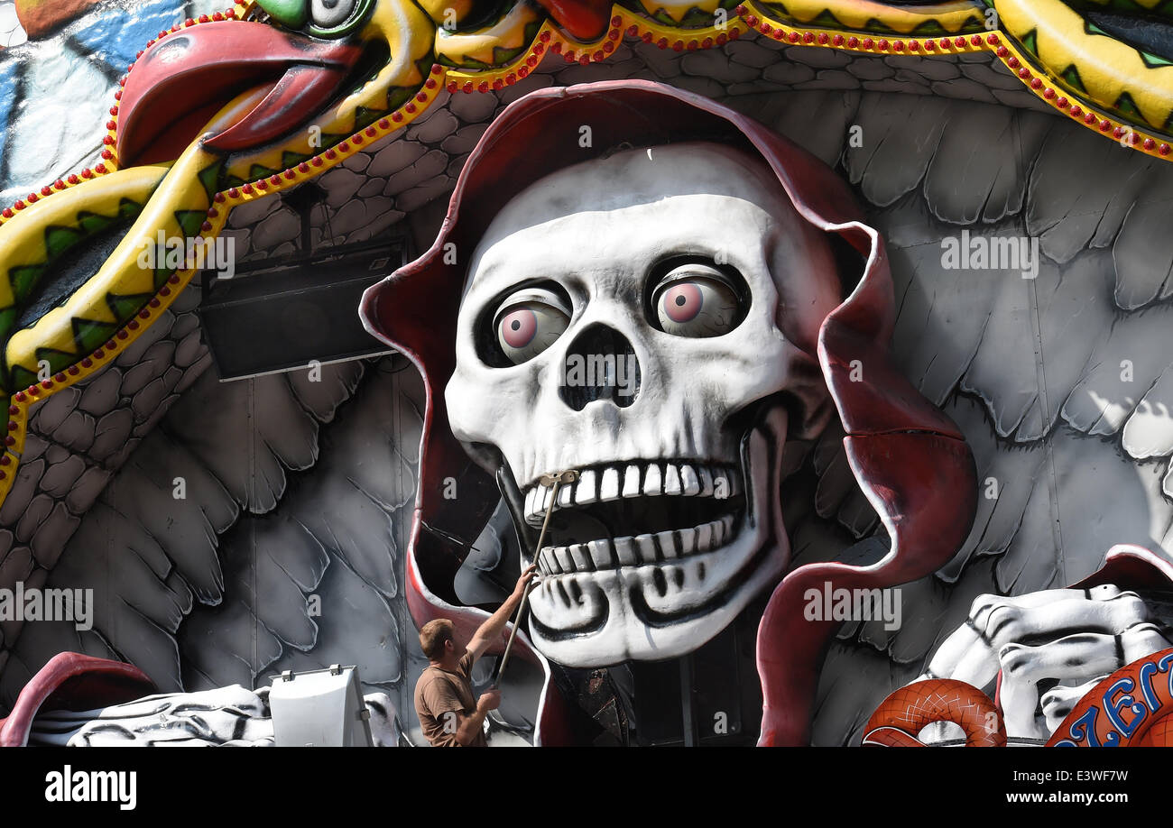 Hanover, Germany. 30th June, 2014. An employee cleans a skull on the facade of a ghost train at the Schuetzenplatz in Hanover, Germany, 30 June 2014. The 485th marksmen's funfair Hanover Schuetzenfest takes place from 04 till 13 July 2014. The marksmen's parade starts on 06 July 2014 at 10:00 CET. Photo: Holger Hollemann/dpa/Alamy Live News Stock Photo