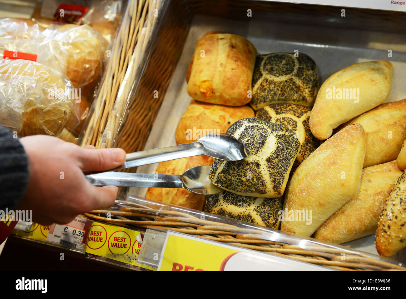 A customer selecting a bread roll in a supermarket Stock Photo Alamy