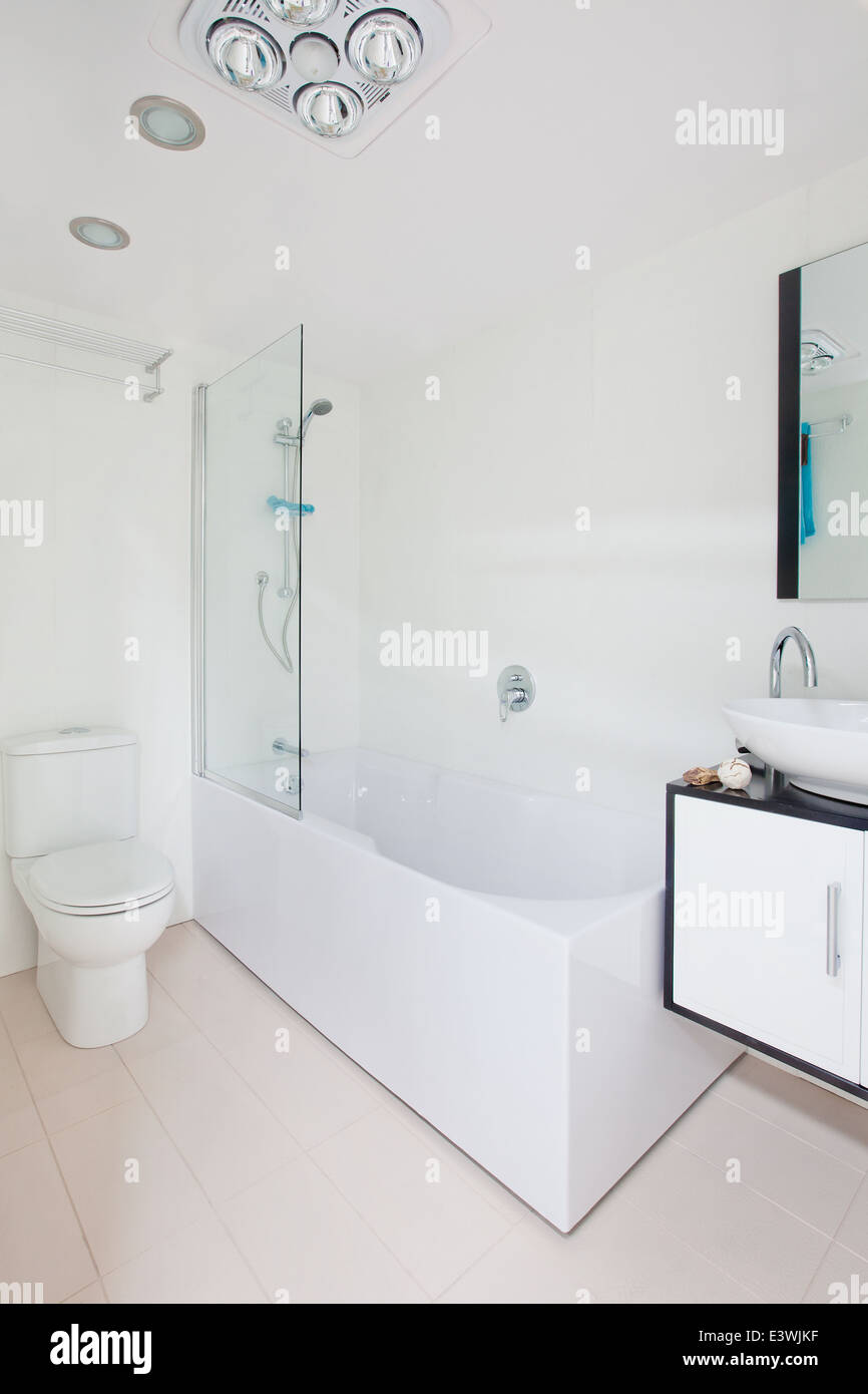 clean compact modern bathroom new commercial. including - mirror, shower, sink, toilet, tiles, cubical, storage. no people. Stock Photo