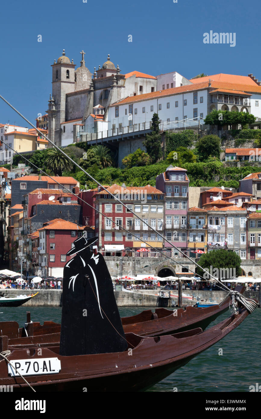 Sandeman Port symbol on a traditional barcos rabelos boat with the historic Ribeira district and the former Bishops' Palace in Stock Photo