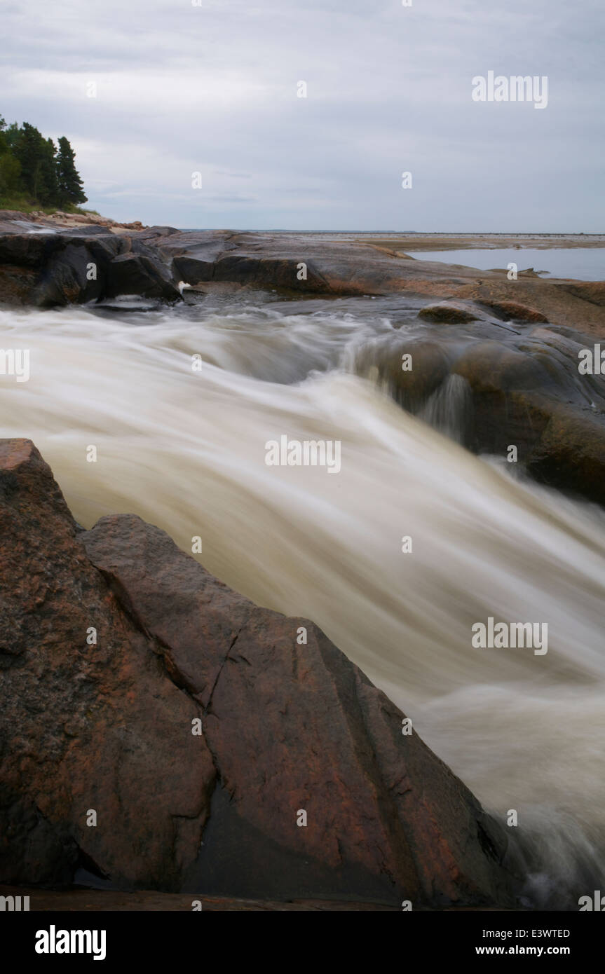 Water filled with forest tannins flowing over rocks down to the St